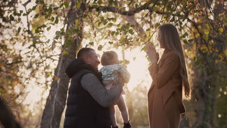 familia feliz con un niño divertirse en el parque de otoño