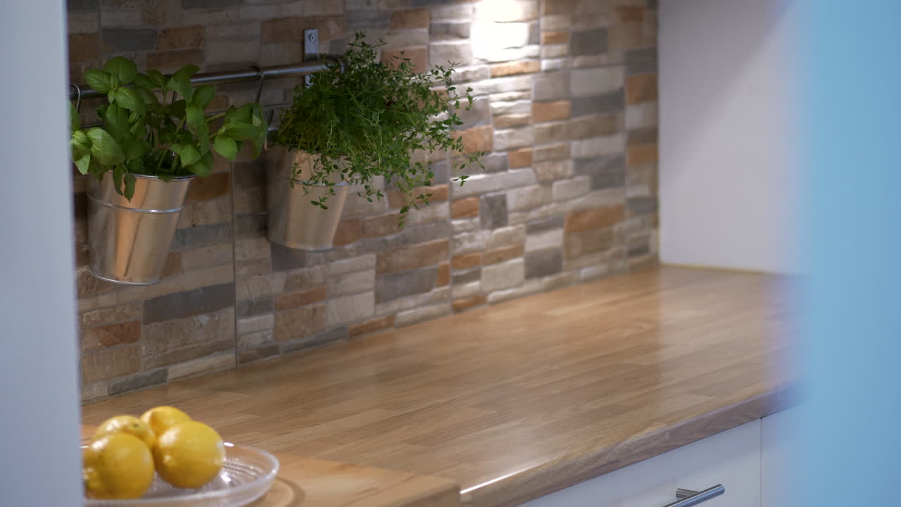 Interno di una cucina moderna con limoni freschi e piante in crescita, ripresa in movimento