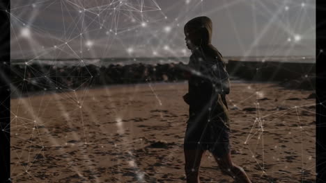 Walking on beach, person with animated network connections overlay, enjoying scenery