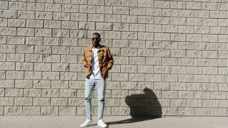 Stylish Man Dancing in Front of a Brick Wall