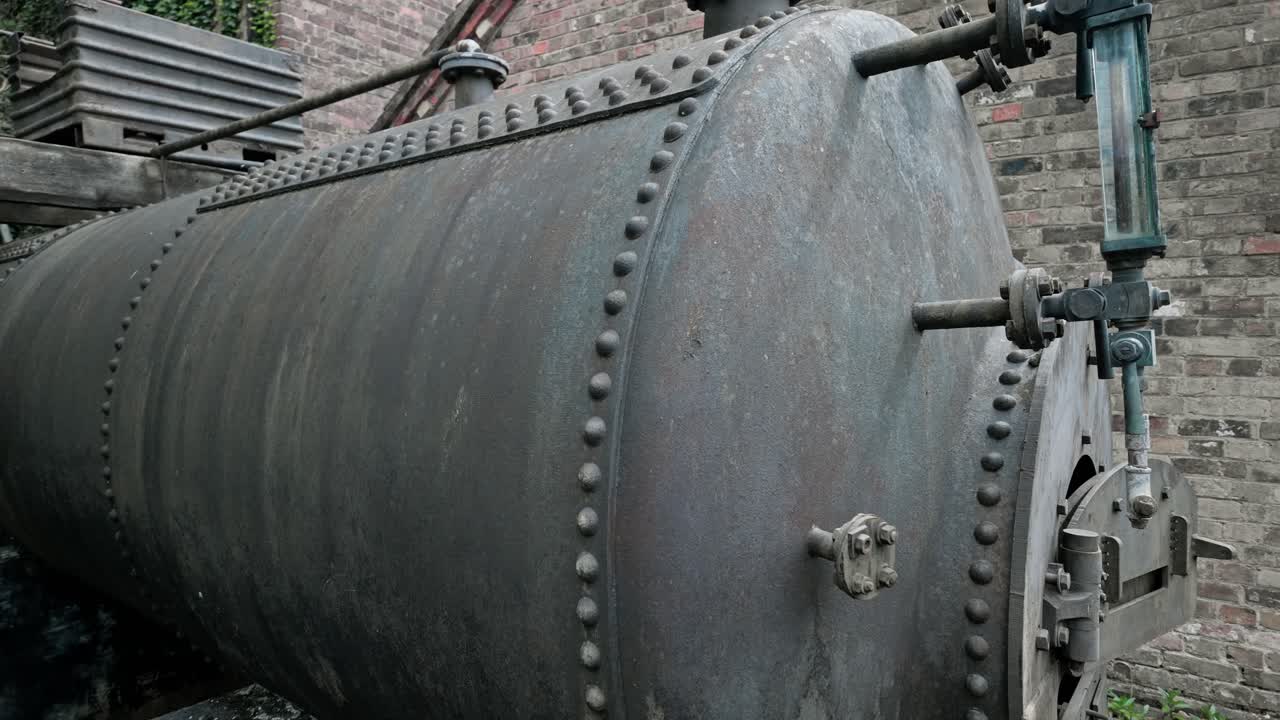 Old vintage riveted cast iron industrial steam boiler outdoor