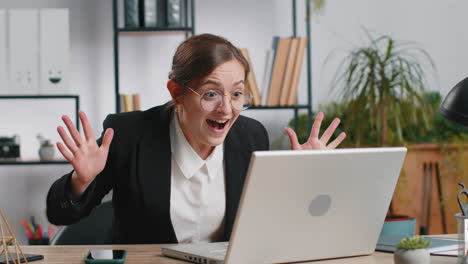 Businesswoman-winner-working-browsing-typing-on-laptop-at-office-celebrate-big-lottery-win-good-news