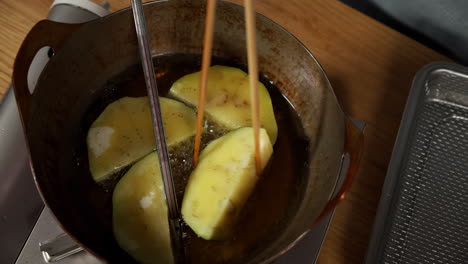 a chef deep frying kamonasu at her home kitchen, tokyo, japan