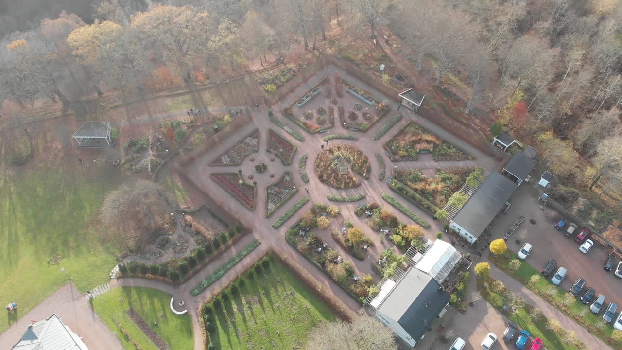 jardines de mansión formales en el sol de la tarde de otoño, drones volando alto