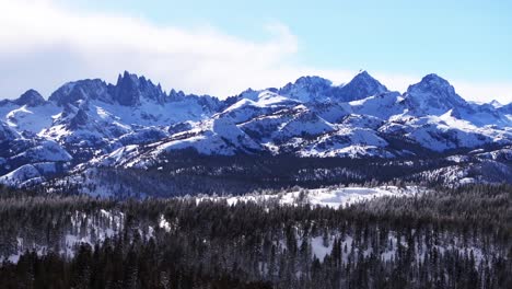 minarets jagged peaks mountain summit vista panoramic landscape aerial drone winter mammoth mountain ski resort california inyo national forest the hemlocks sunny blue skies cloudy downward jib motion