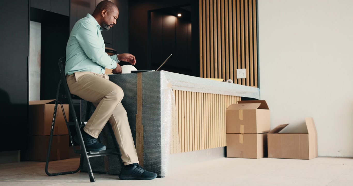 Man Working on Laptop at Construction Site Reception Desk