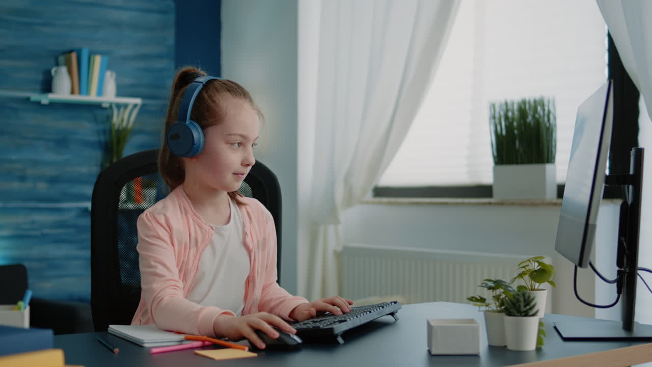 Young child drawing on textbook and using computer
