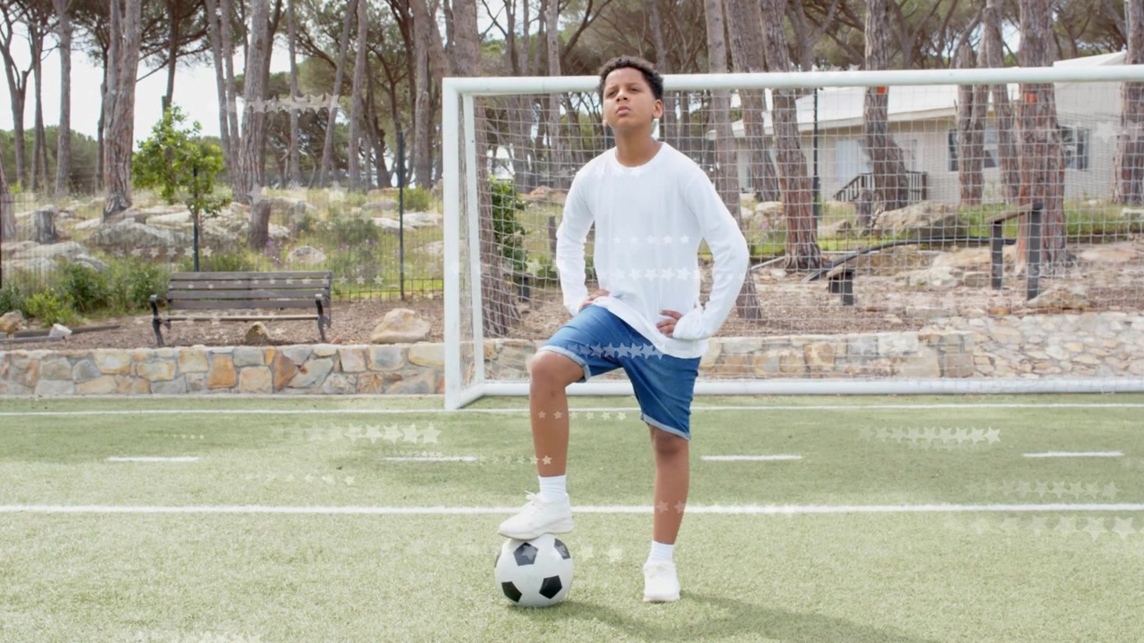 Niño colocando el pie derecho sobre un balón de fútbol, cambiando el peso y preparando el tiro en un campo deportivo