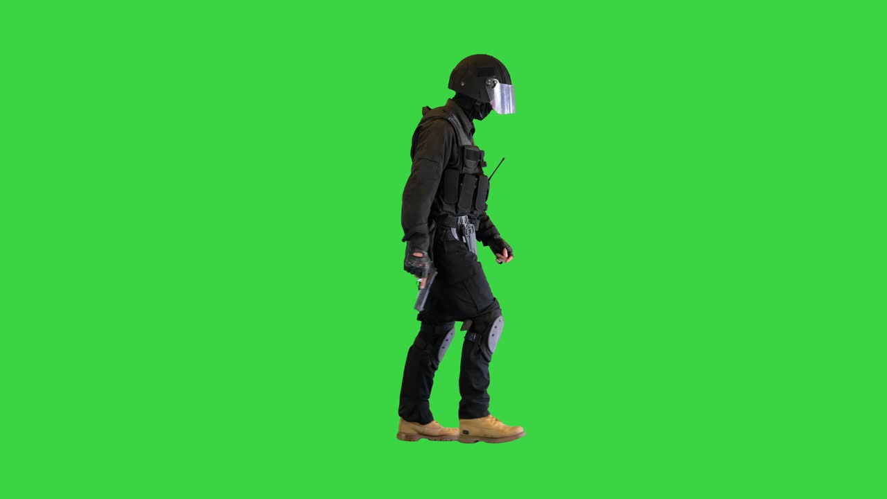 Counter terrorist squad fighter walking with a pistol in a hand on a Green Screen, Chroma Key