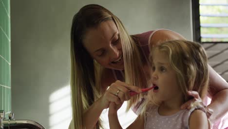 madre e hija cepillándose los dientes juntos