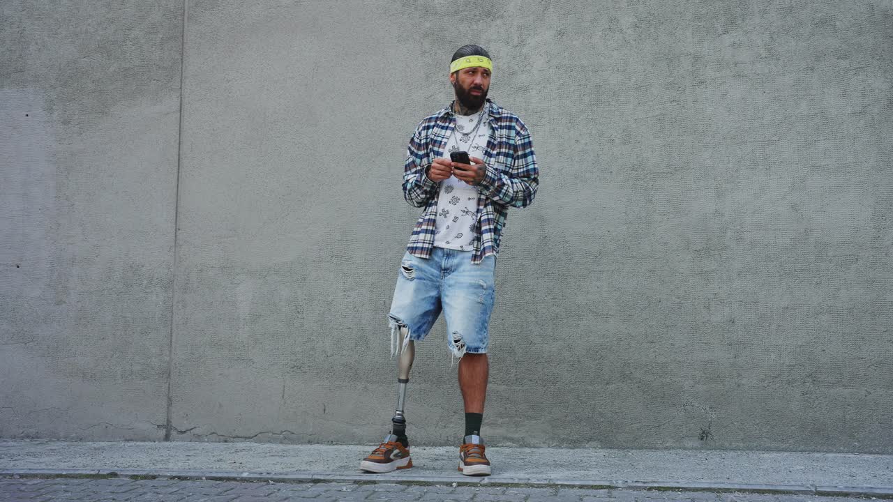 Mies proteesijalalla käyttämässä älypuhelinta