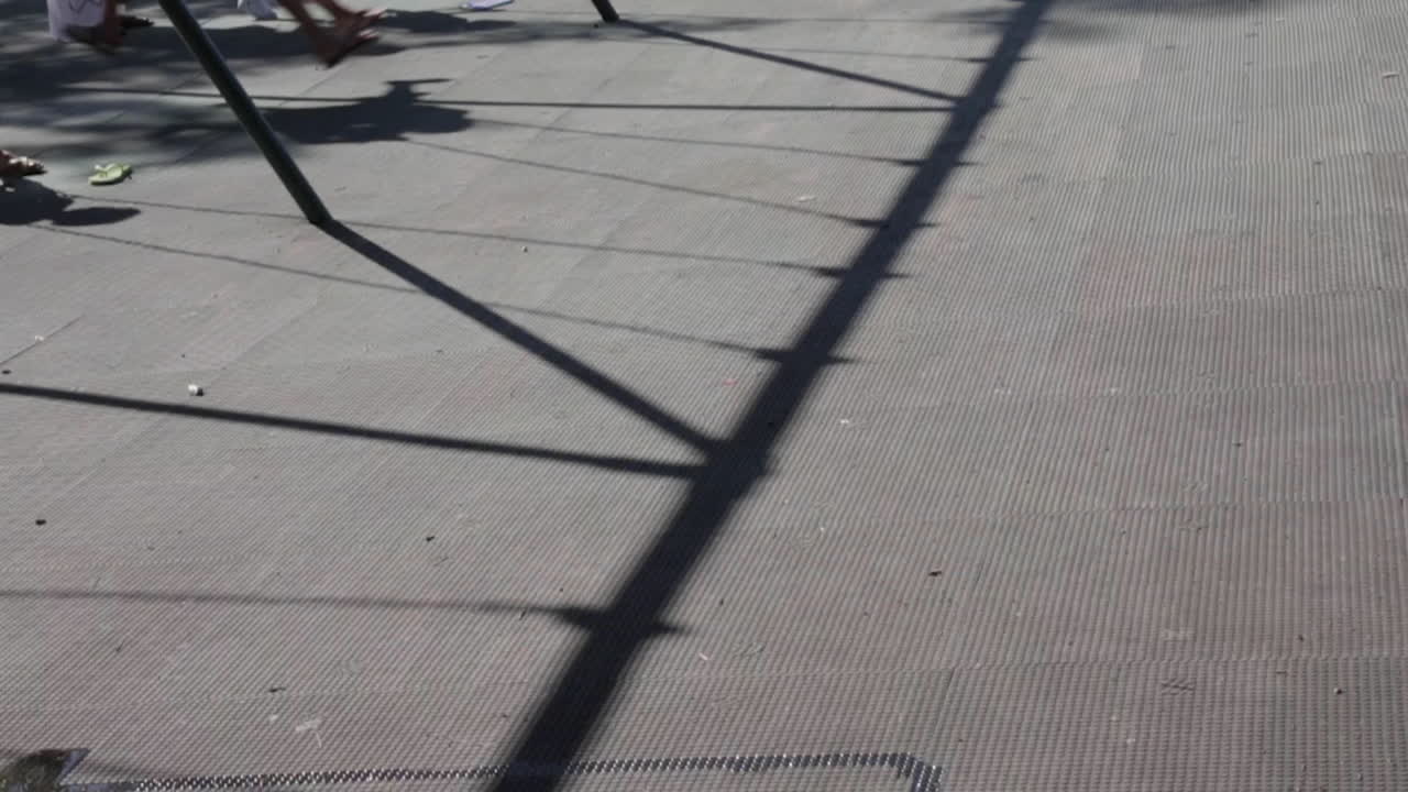 공원에서 그네를 탄 아이들, 그네 세트에서 땅에 드리운 그림자, 느린 동작