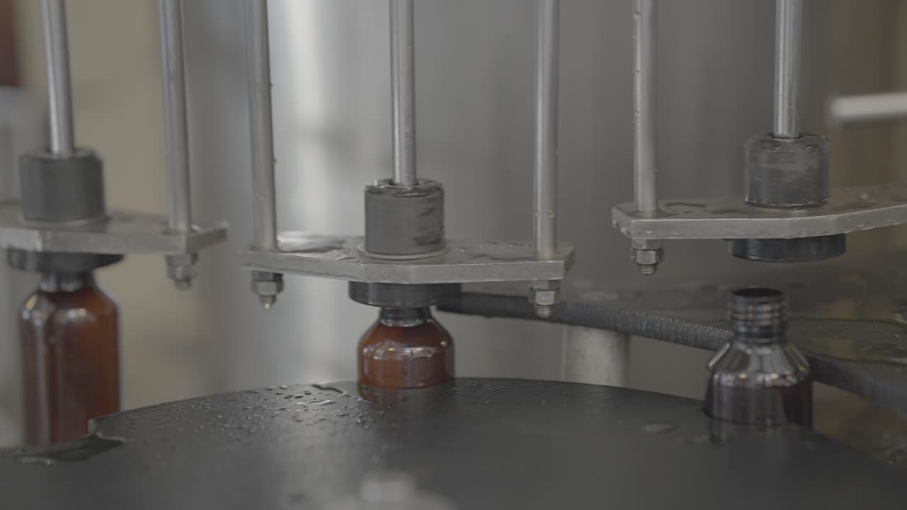 Syrup Bottles getting filled with liquid medicine close up shot slog footage.