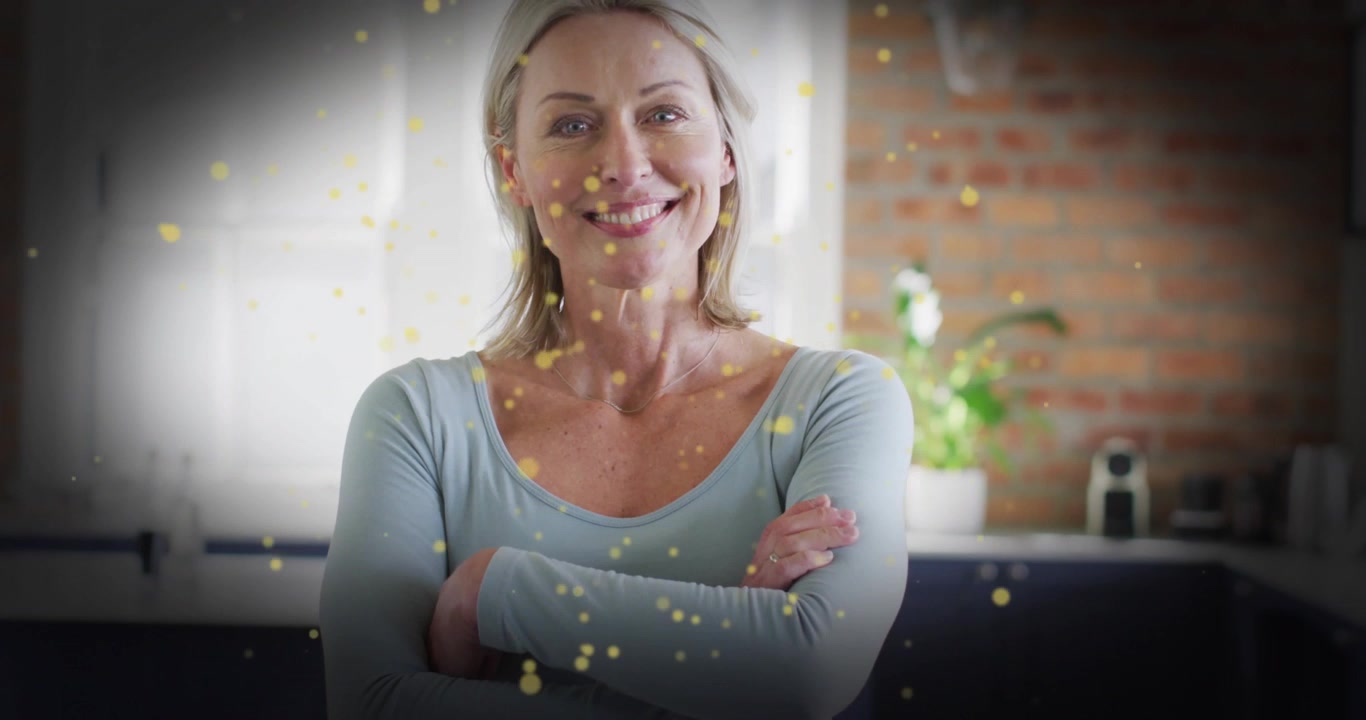 Benessere che mostra particelle d'oro che fluttuano sulla cucina, motivando una donna che incrocia le braccia e sorride