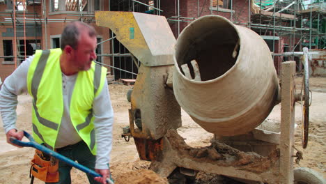 trabajador de la construcción en el sitio de construcción mezclando cemento