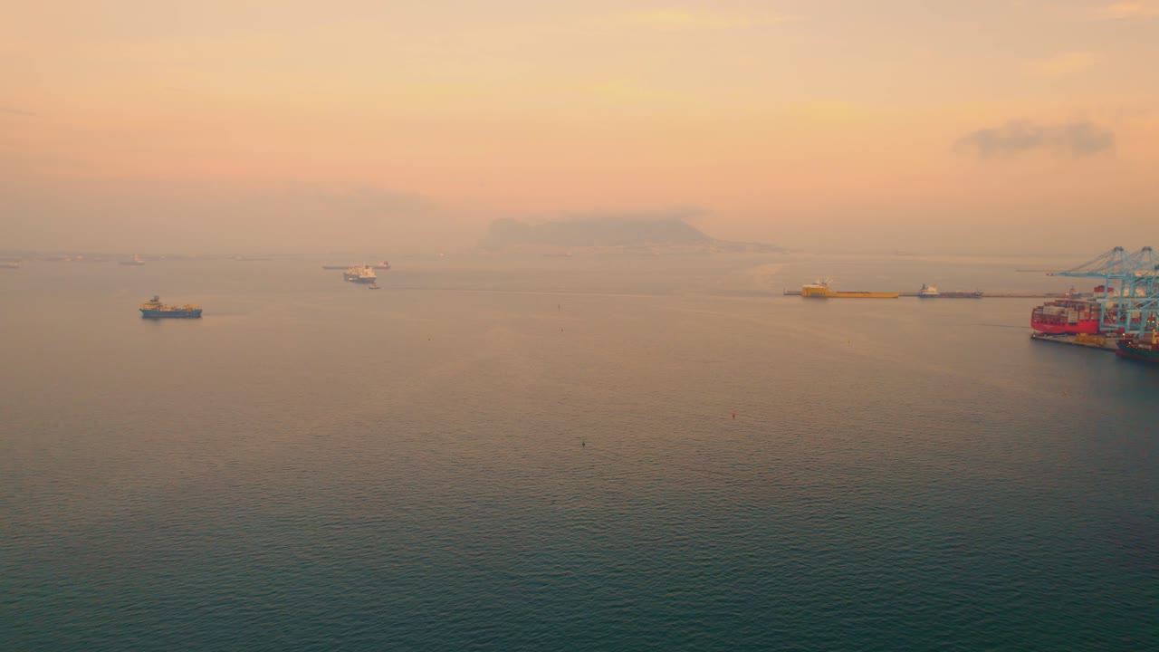 지중해 일출 바다를 가로질러 알헤시라스 국제 선적 터미널 항구를 향해 여행하는 컨테이너선