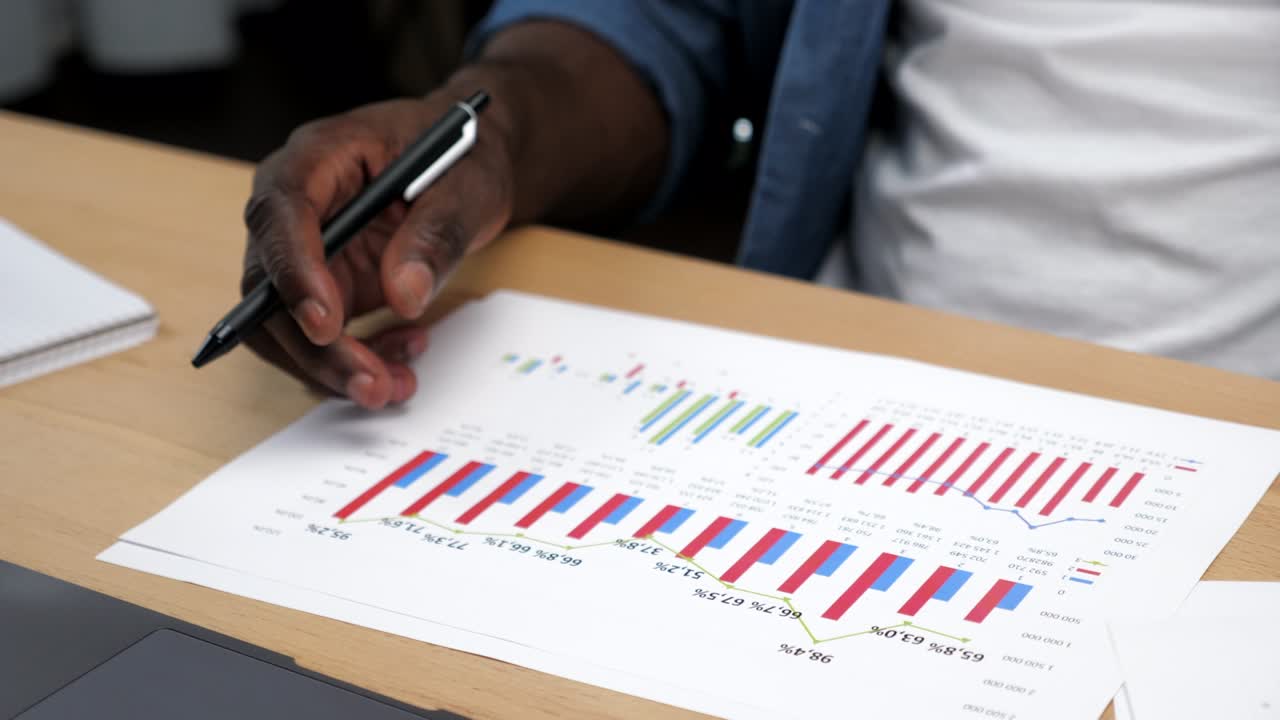 African American businessman looks business report with chart company indicators