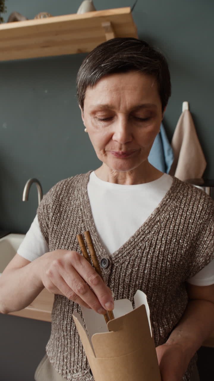 Woman Enjoying Takeout Noodles with Chopsticks