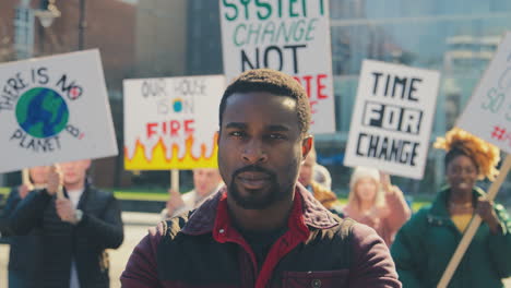 portrait of protestors with placards chanting slogans on demonstration march against climate change