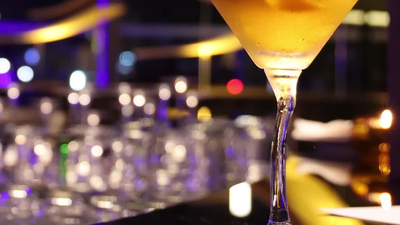 bicchiere di martini che rovescia e versa lentamente il liquido
