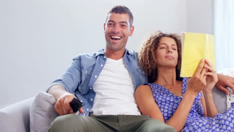 cute couple watching tv and reading
