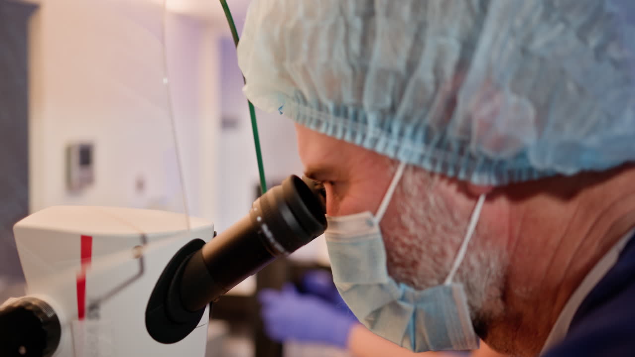 ученый смотрит через микроскоп в лабораторной обстановке