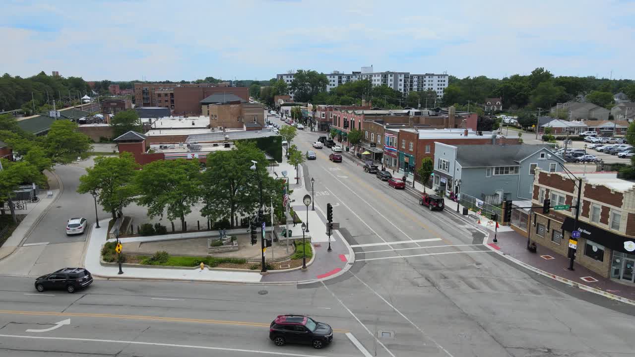 Drone shot of Lombard, Illinois, capturing suburban streets, train tracks, and mixed residential and commercial buildings. Crane Down Cloudy Day W