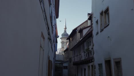 Pigeons-flying-on-rooftop-in-urban-medieval-town-with-the-cathedral-tower-in-the-background