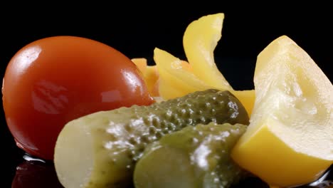 disparo de verduras encurtidas rotativas sobre un fondo negro