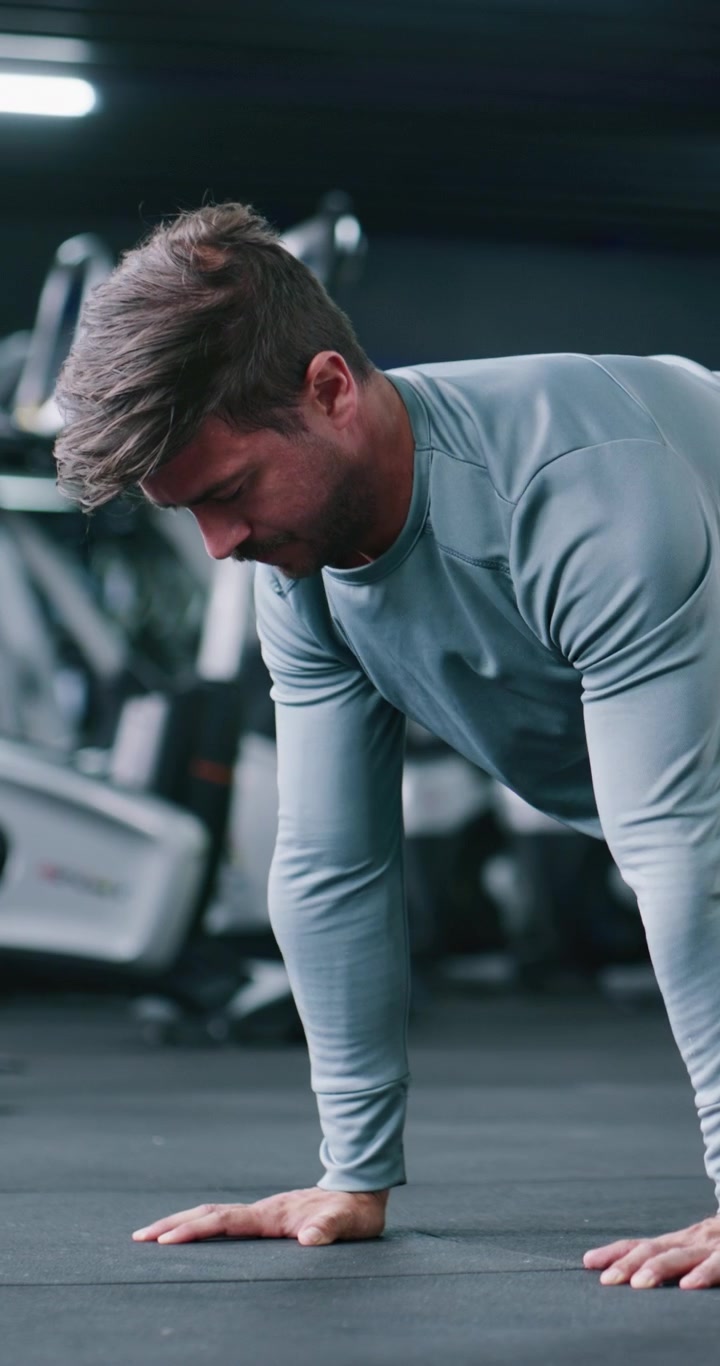 Young Man Performing Push-Ups in a Modern Gym