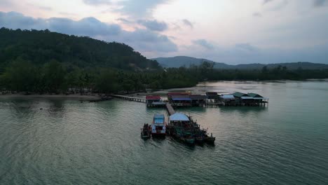 cambodia koh rong island, capturing the essence of tropical paradise with its lush palm trees, vibrant turquoise waters, and traditional stilt houses. lovely aerial view static tripod hovering drone