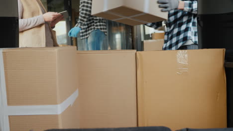 cardboard boxes are loaded into the trunk of the van