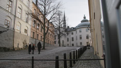 Zwei-Erwachsene-Und-Ein-Kind-Genießen-Einen-Weihnachtlichen-Morgenspaziergang-Auf-Kopfsteinpflaster-Im-Stenbock-Palast-Riddarholmen-Gamla-Stan-In-Stockholm,-Schweden