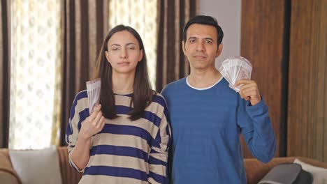 indian couple using money as fan