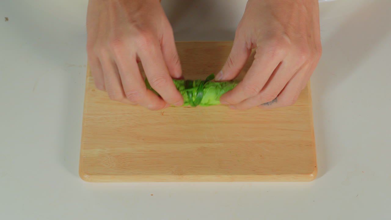 chef hand top down view sealing a vegan spring roll traditional healthy Vietnamese cuisine