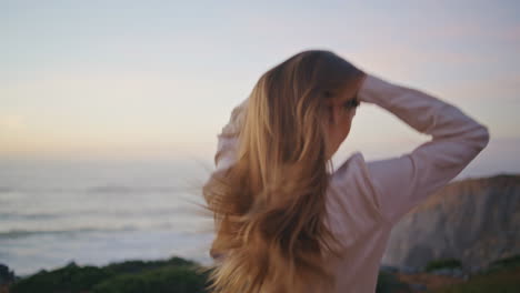 happy woman running evening hill back view. carefree model girl touching hair