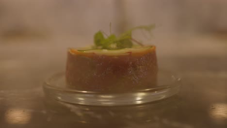 close up shot of glass jar filled with smoked being lifted to reveal tartare of meat