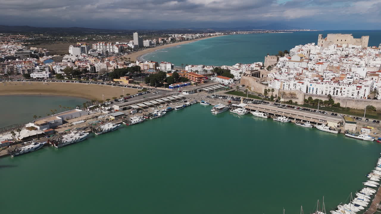 Wide sweep over harbor with Castell de Peniscola and whitewashed buildings below