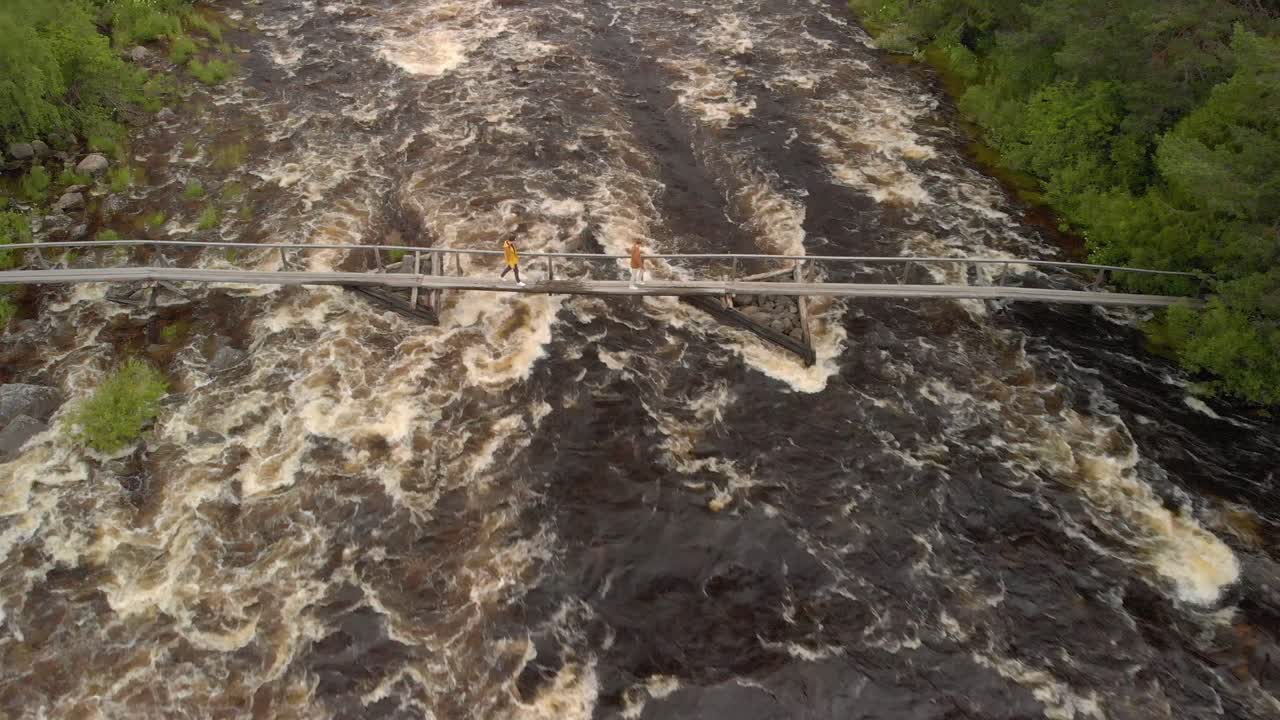 칼릭스 래피드 위의 작은 다리 위를 걷는 두 남자의 드론 항공 영상