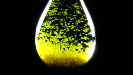 abstract microscopic view of yellow-green particles in liquid