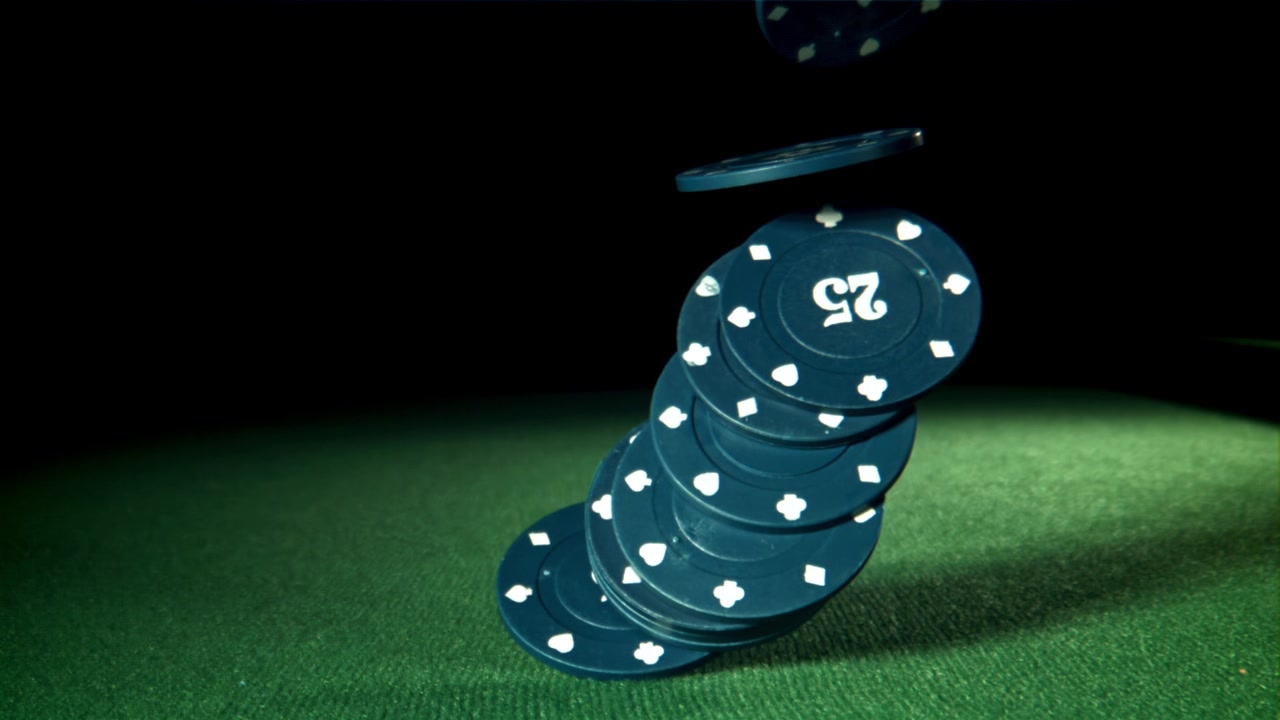 Slowmotion blå pokerchips falder på grønt filtbord