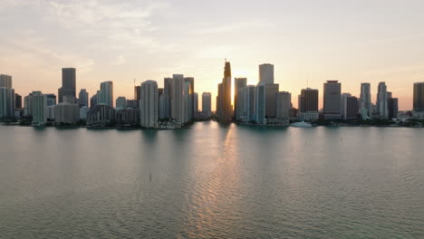 Slider-of-modern-tall-residential-houses-on-waterfront-against-sunset.-Silhouette-on-modern-city-borough.-Miami,-USA