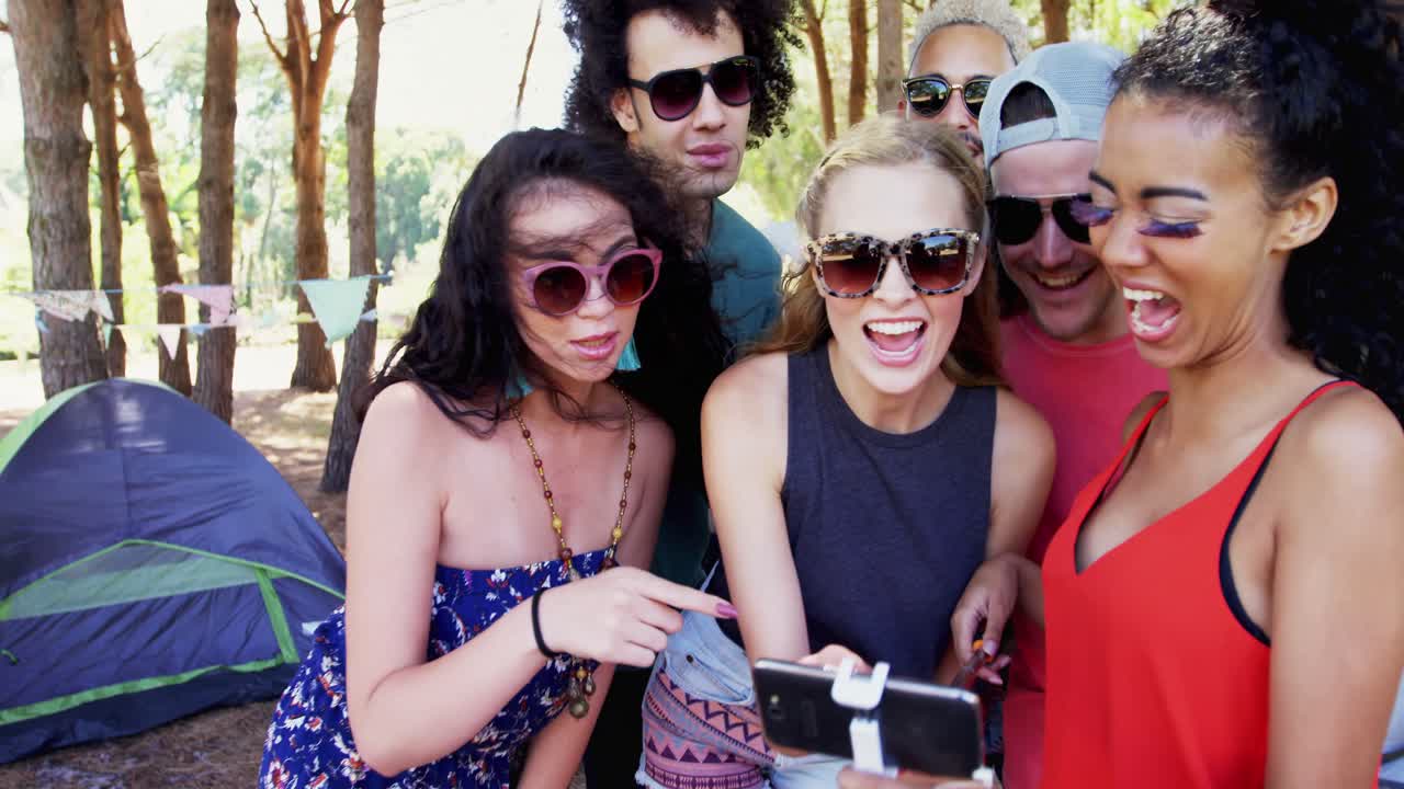 친구 들 이 4k 공원 에서 휴대 전화 를 보고 있다