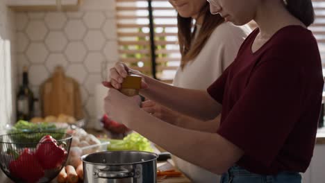 caucasian mother teaching daughter how cook the soup