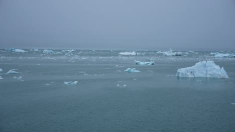 Segeln-An-Eisstücken-Im-Kalten-Ozeanwasser-Mit-Nebligem-Horizont