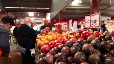 vendor and customers at fruit shop in market