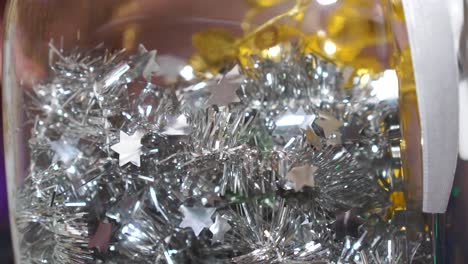 decoración de navidad de plata y oro brillante cuerda en frasco de vidrio, mano de mujer