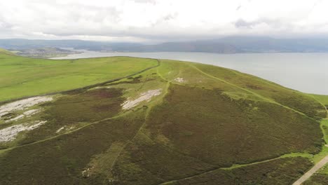 Aerial-view-flying-above-Great-Orme-Llandudno-mountain-valley-rural-landscape-overlooking-England-summit