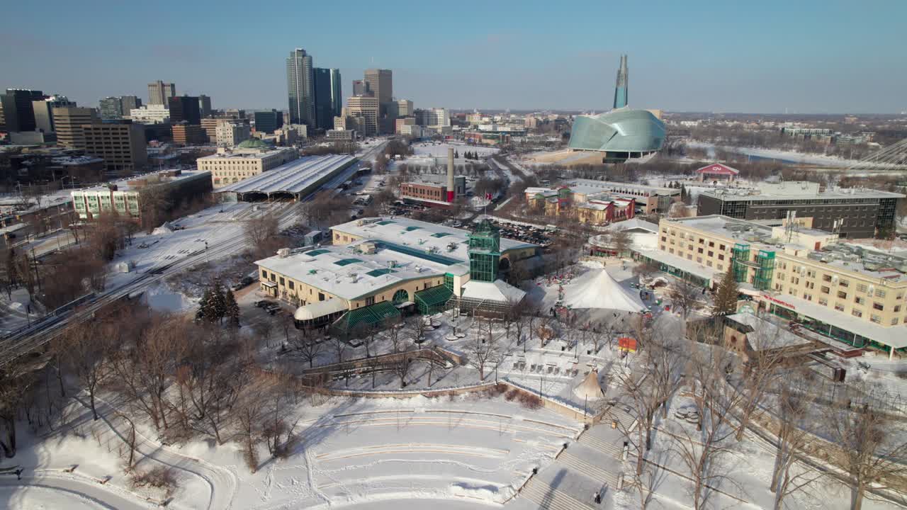 Gorgeous winter aerial of Winnipeg, MB skyline, The Forks, Human Rights Museum and Assiniboine River, 4K