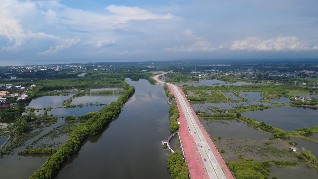 Aerial view of a highway bridge over a river with mangroves